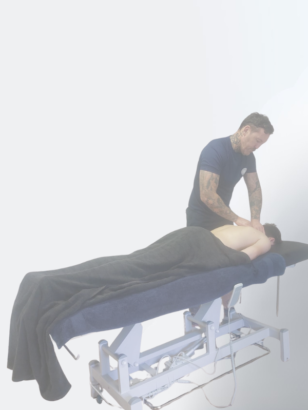 Massage therapist performing deep tissue treatment on a client lying face down on a therapy table